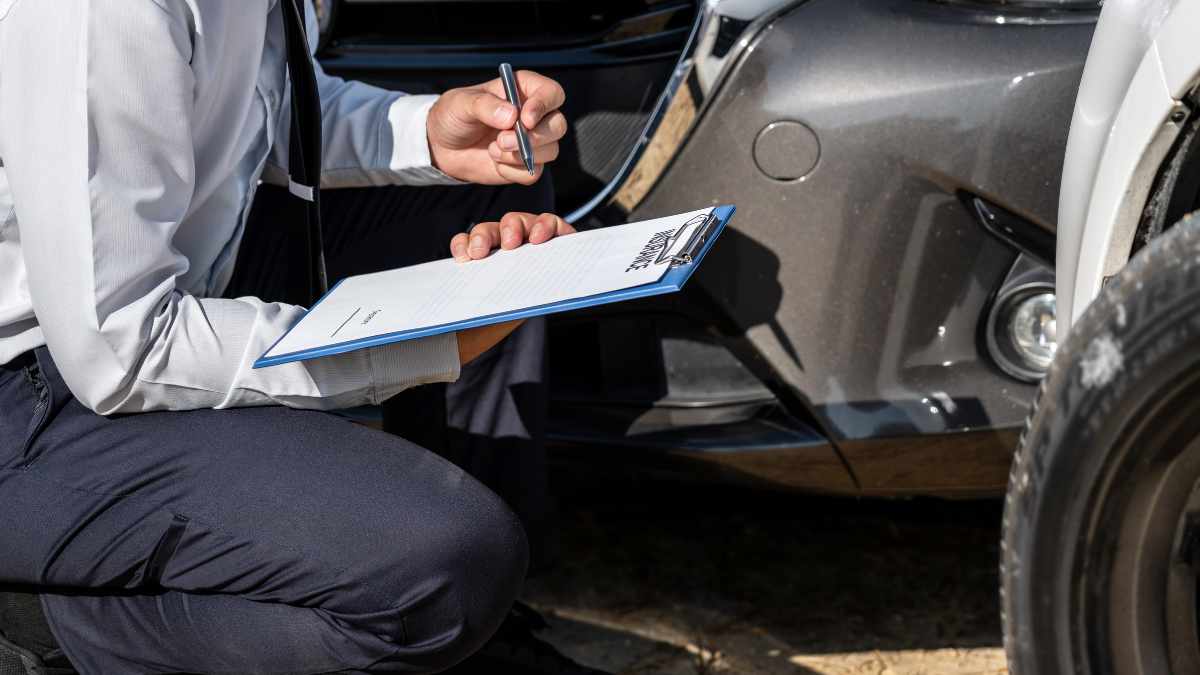 An insurance agent inspecting a salvage vehicle